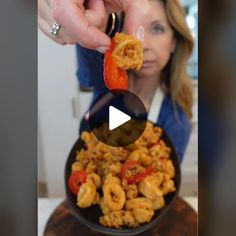 a woman is holding a piece of food in front of her face