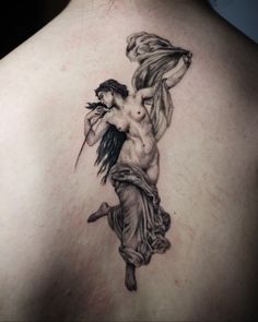 the back of a woman's shoulder with a tattoo on it