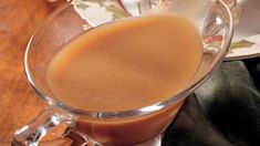 a glass cup filled with liquid on top of a wooden table