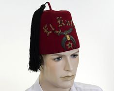 This hat was found in a vintage store over 40 years ago.  Great EL KATIF Shriners red wool fez with a black tassel.  Embellished with bullion embroidery and a pharaoh's head.  It also has it's original bag.  A wonderful piece for your hat collection or use as a theatrical prop. Manufacturer:  Hefter-Ribb Co., NY              Year:  1970's Condition:  Hat is in good pre-owned vintage condition.   Hat is clean, no holes or stains.  Tassel is intact.  Original bag included.  Has company info stamped inside.  Sold in AS IS condition.  View all photos before purchasing. Measurements:  6" tall / Inside Measurement 21" / Tassel 10.5" Long from top of hat Fez Hat, Bullion Embroidery, Hat Collection, Costume Hats, Original Bags, Red Wool, Book Decor, Vintage Store, 40 Years