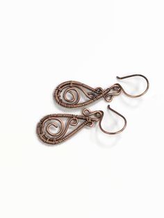 two pairs of copper wire earrings on white background with clippings to the side