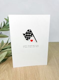 a card with a black and white checkered flag on it, next to a plant