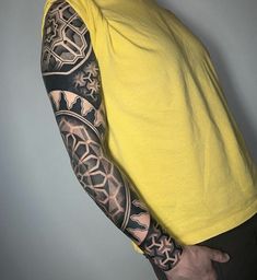 a man wearing a yellow shirt with tattoos on his arm and shoulder is posing for the camera