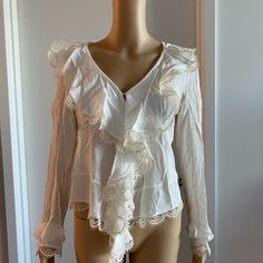 White Long Sleeve Blouse With Embroidered Lace Embellishment On Ends Of Sleeves, Shoulders And Front 100% Silk In Overall Great Condition With Only A Couple Very Small Tears On The Shoulders As Shown In Images Chest - 17" Sleeve - 23.5" Length - 24.5" Elegant V-neck Lace Top For Brunch, Elegant White V-neck Lace Top, White V-neck Blouse With Ruffles, V-neck Blouse With Lace Trim For Daywear, V-neck Blouse With Lace Trim For Brunch, Chic Long Sleeve Top With Floral Embroidery, Chic Long Sleeve Tops With Floral Embroidery, Chic Floral Embroidered Lace Top, Chic V-neck Lace Top With Ruffles