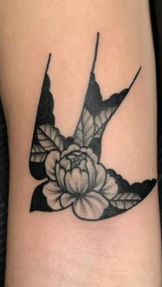 a black and white bird with flowers on it's side tattoo by the artist