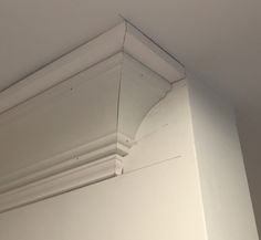 the corner of a room with white paint and mold on the ceiling above it is an object that appears to have been painted