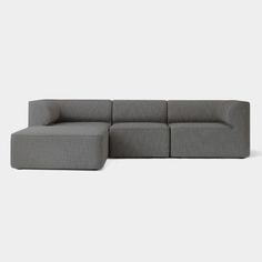 a gray sectional couch sitting on top of a white floor