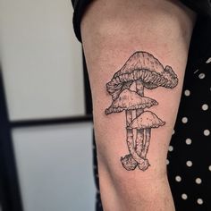 a woman's arm with a mushroom tattoo on it