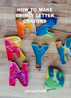 the letters have been made out of colorful marbled paper and are sitting on a wooden surface