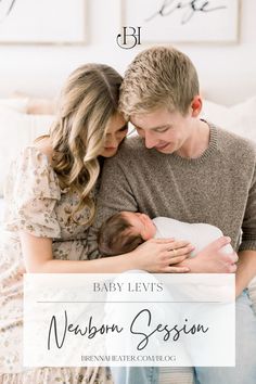 a man and woman holding a baby in their arms with the words, baby levi's newborn session