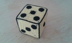 a crocheted dice sitting on top of a wooden table