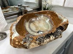 a bowl shaped sink sitting on top of a white counter next to a bathroom mirror