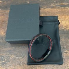 Handcrafted from premium leather Astro is an elegant bracelet, as tough as it looks. Red leather strips weave up and down the wide band, adding a dash of spark. With a minimalistic magnetized stainless steel clasp in black rhodium, it stacks effortlessly with other bracelets and watches, but is substantial enough to hold its own. Premium Nappa Leather Stainless Steel Clasp with Rhodium Bracelet, 10mm Wide Modern Leather Braided Bracelets, Modern Leather Braided Bracelet With Black Band, Modern Black Leather Bracelet With Stainless Steel Clasp, Modern Braided Leather Bracelets With Black Band, Modern Black Braided Bracelet With Leather Strap, Modern Black Rectangular Leather Bracelet, Black Leather Bracelet With Stainless Steel Clasp As Gift, Black Leather Braided Bracelet With Stainless Steel Clasp, Modern Leather Braided Bracelet With Stainless Steel Clasp