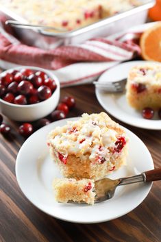 a piece of cranberry coffee cake on a plate with a fork and bowl of cherries in the background