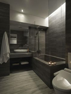 a bathroom with a toilet, sink and bathtub next to a shower head mounted on the wall