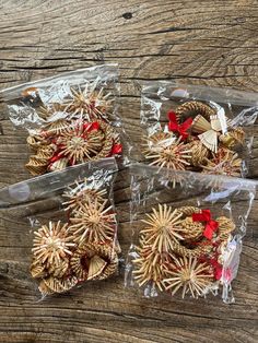 three packaged cookies in plastic bags with red bows on the top and one wrapped in clear cellophane