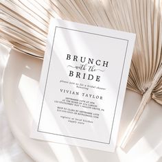 the brunch with the bride wedding card is on top of a plate next to a fan