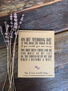 some flowers and a card on a wooden surface with words about wedding day written in it