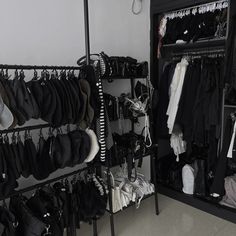 a closet filled with lots of clothes next to a wall mounted rack full of shoes