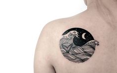 the back of a woman's shoulder with an image of a wave on it