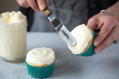 a person cutting into cupcakes with a knife