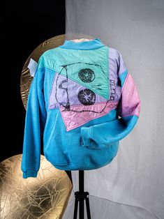 This is a cotton sweater with color blocked nylon paneling, and an original artist print. Individuation in is yours for the taking. Blue Color Block Sweater For Streetwear, Retro Patchwork Sweatshirt For Streetwear, Sporty Cotton Patchwork Sweater, Retro Patchwork Sweatshirt For Fall, Retro Multicolor Graphic Print Sweatshirt, Retro Cotton Patchwork Sweatshirt, Retro Cotton Patchwork Sweater, Blue Retro Sweater With Graphic Print, Blue Patchwork Sweatshirt For Streetwear