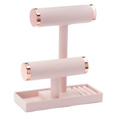 a pink and gold holder with two rolls of toilet paper on it's sides