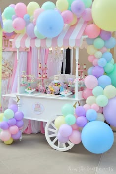 an ice cream cart decorated with balloons and streamers for a birthday party or baby shower