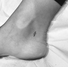 a small tattoo on the foot of a person with a lightning bolt tattooed on it