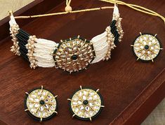 Welcome to Adornn Jewels This Choker jewellery set consists of a necklace, finger ring and a pair of earrings Gold-plated necklace has Green KUndan and Beads details Secured with a drawstring closure A matching pair earrings, each secured with a post-and-back closure Gold-plated adjustable finger ring  Size & Fit Length of the Necklace : 44 cm Length of the Earring : 3 cm Diameter of Finger ring: 2 cm(Adjustable) Material & Care Material: Alloy Plating: Gold-plated Stone type: Kundan & Beads Care Instructions Wipe your jewellery with a soft cloth after every use Always store your jewellery in a flat box to avoid accidental scratches Keep sprays and perfumes away from your jewellery Do not soak your jewellery in water Clean your jewellery using a soft brush, dipped in jewellery cleaning sol Polki Sets, Choker Jewellery, Indian Choker, Kundan Choker, Jewelry Cleaning Solution, Kundan Necklace, Choker Set, Bridal Jewellery Indian, Kundan Necklaces