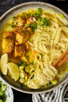 a bowl filled with noodles, tofu and vegetables