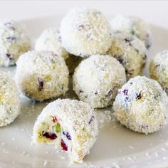 a white plate topped with cut in half desserts covered in powdered sugar and cranberries