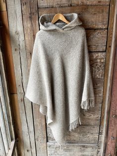 Beige wool blanket poncho cape hooded Light beige hooded poncho cape with fringes Long wool poncho cape Lambswool blanket poncho cape One size fits fashionably for most everyone, short or tall, big or small. This piece is versatile for both Men's & Women's outdoor fashion, and can be used insider in cooler winter weather to keep warm while reading on the couch. CARE: Hand-wash and hang to dry, light iron if needed, or dry clean. MEASURES: Length at the front of the neckline to the bottom is ~120 Cozy Wool Poncho Cape, Beige Hooded Poncho For Fall, Cozy Beige Wool Poncho, Beige Winter Cape Poncho, Beige Shawl Cape For Winter, Beige Winter Shawl Cape, Cream Winter Cape Poncho, Cream Cape Poncho For Winter, Cream Poncho Cape For Winter