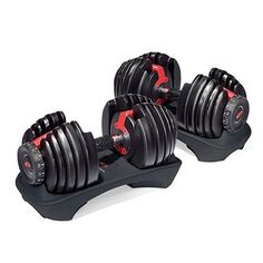 two black dumbbells sitting next to each other on top of a white table