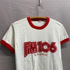 Small / 1980s Red/White Two Tone Ringer FM106 The Best Music USA Made T Shirt Pit to Pit: 17in + Stretch // Top Collar to Bottom: 24in Tagged M, fits modern S. Check measurements! Retro White Top With Band Logo, Retro White Tops With Band Logo, Vintage White Top With Band Logo, Stretch Top, Best Music, How To Make Tshirts, Good Music, Two Tone, Red White