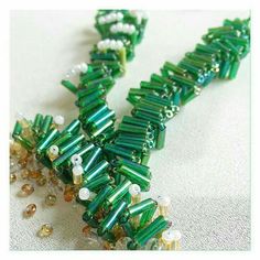 green and white beaded necklace laying on top of a table