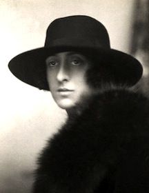 black and white photograph of a woman wearing a hat with fur on the brim