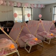 a room filled with lots of pink beds covered in blankets and pillows