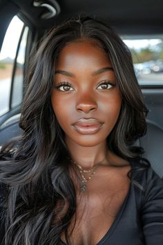 a woman sitting in the back seat of a car looking at the camera with an intense look on her face