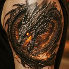 a man's arm with a dragon tattoo on it and an orange eye in the center