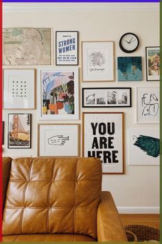 a brown leather chair sitting in front of a wall covered with pictures and framed art