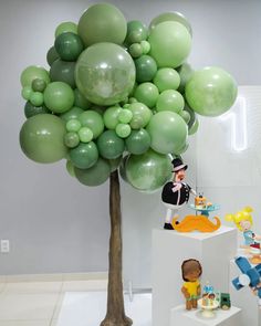 a tree with balloons attached to it in a room