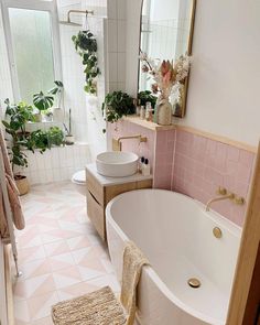 a bath room with a tub a sink and a rug on the floor in front of a window