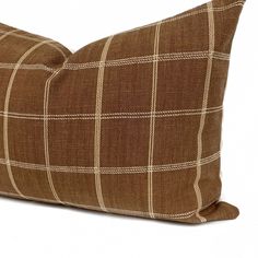 a brown and white checkered pillow on a white background