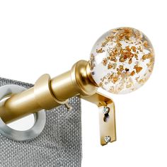 a close up of a curtain rod with a glass ball on the top and gold sprinkles