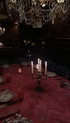 a table with plates and candles on it