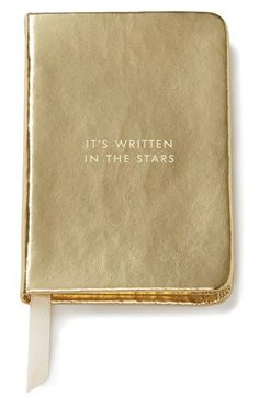 a gold book with the words it's written in the stars