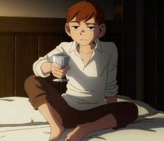 a person sitting on a bed holding a cup