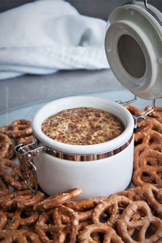 a bowl of food is sitting on a plate with pretzels and sauce in it