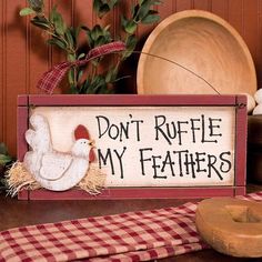 a wooden sign that says don't ruffle my feathers on top of a table